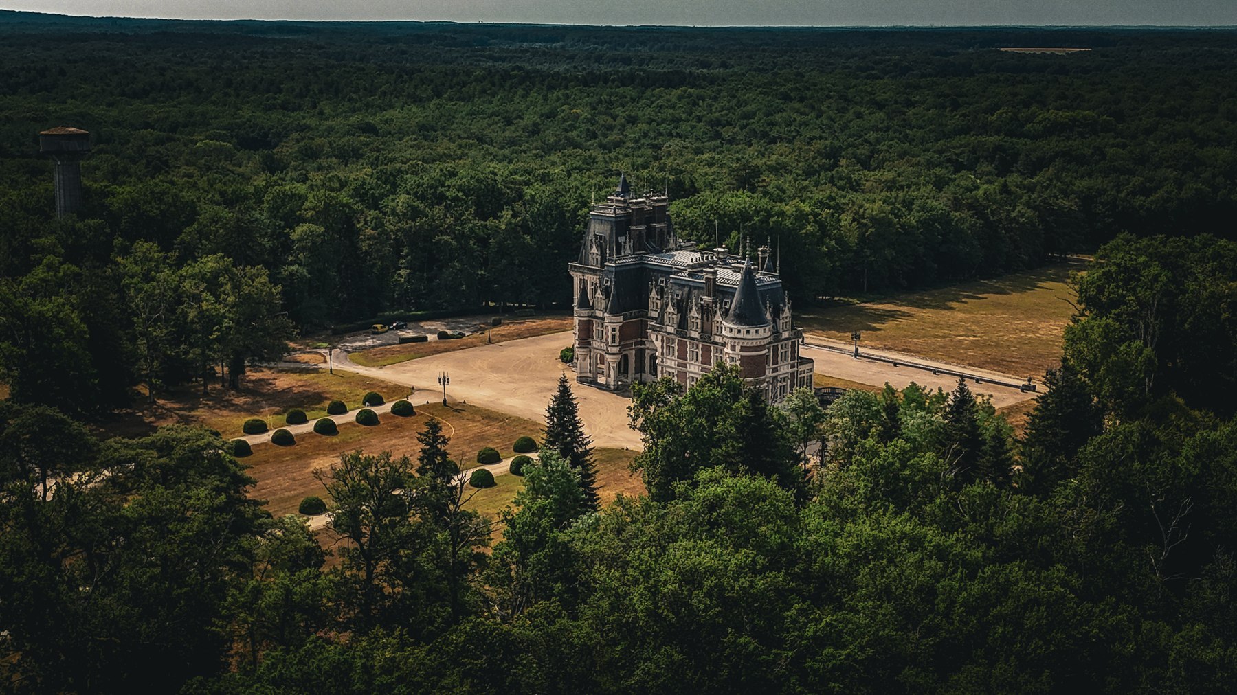 Aerial view of Château Changeux nestled within its forested estate